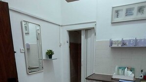 A compact kitchen with a marble countertop, a small refrigerator, a sink, and a mirror. - Guest House Orlihome (Haifa)