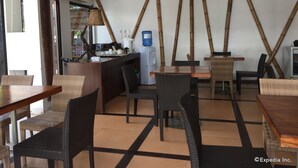Un restaurante con barra, mesas y sillas.