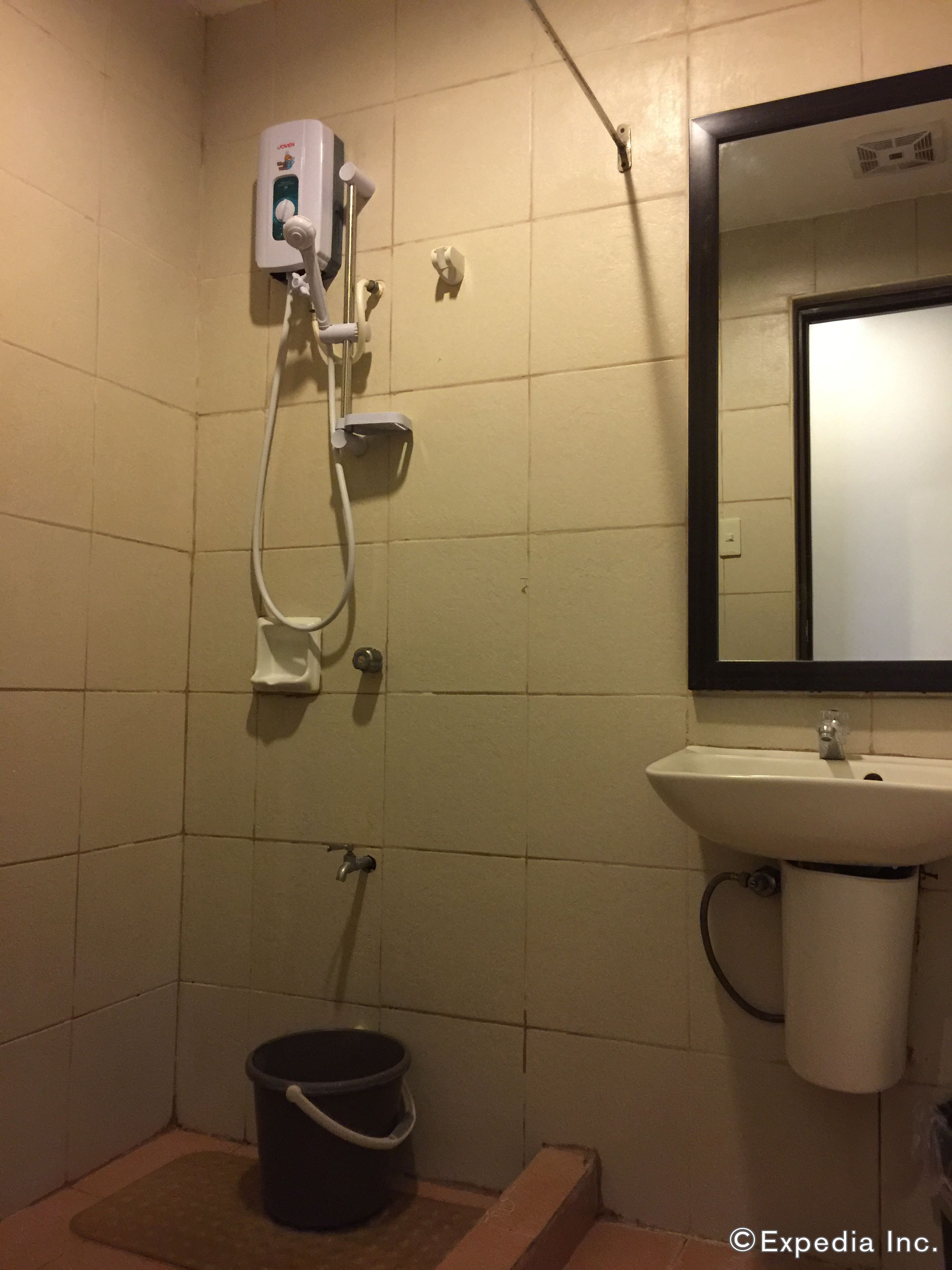 A bathroom with a shower, sink, and a mirror.