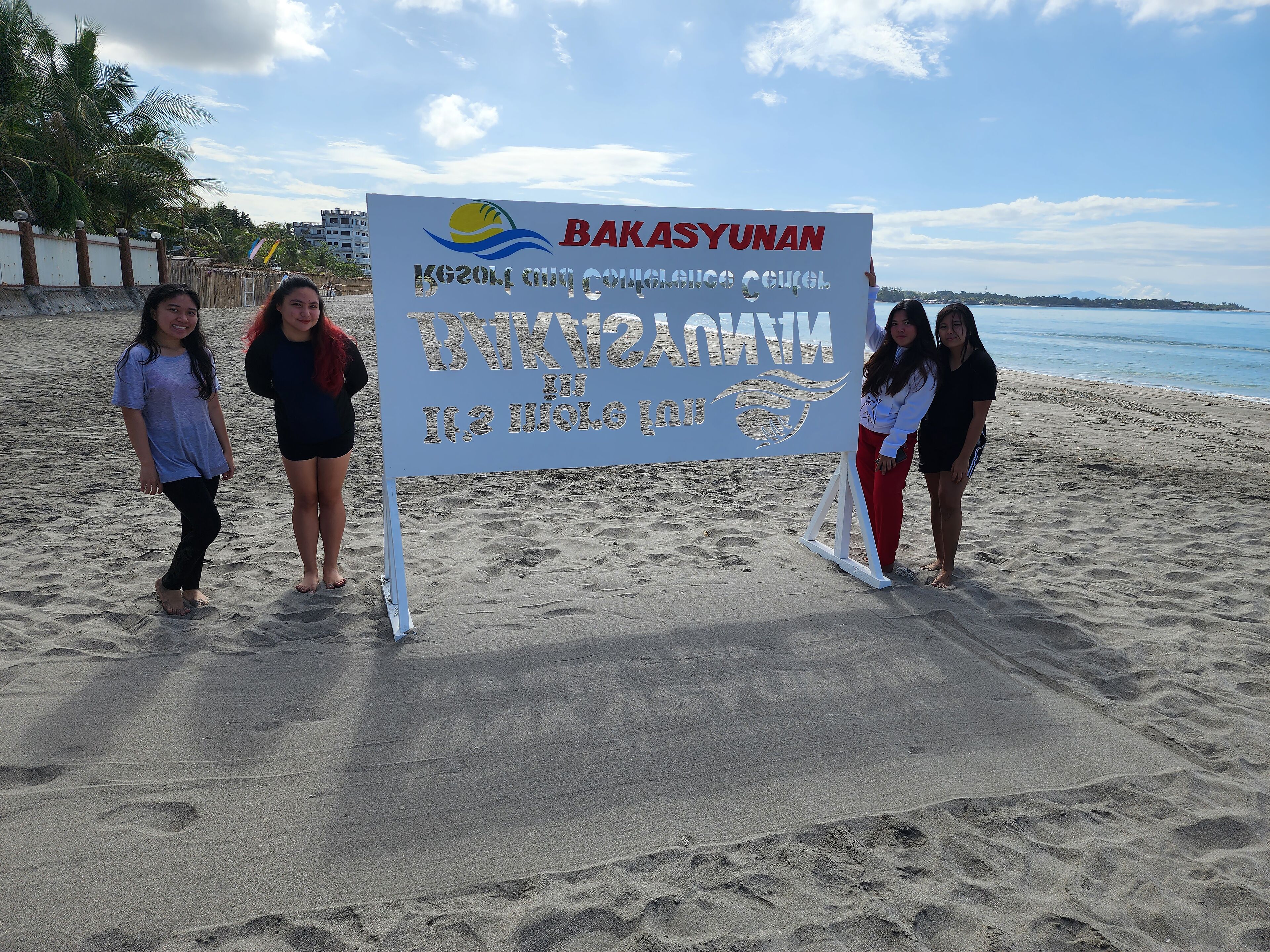 A beach scene with a signboard.