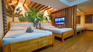 A hotel room with two beds, a TV, and a wooden floor. - Bakasyunan Resort Zambales (Iba)