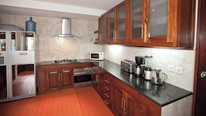 Een moderne keuken met houten kastjes, een magnetron, een broodrooster en een koffiezetapparaat.