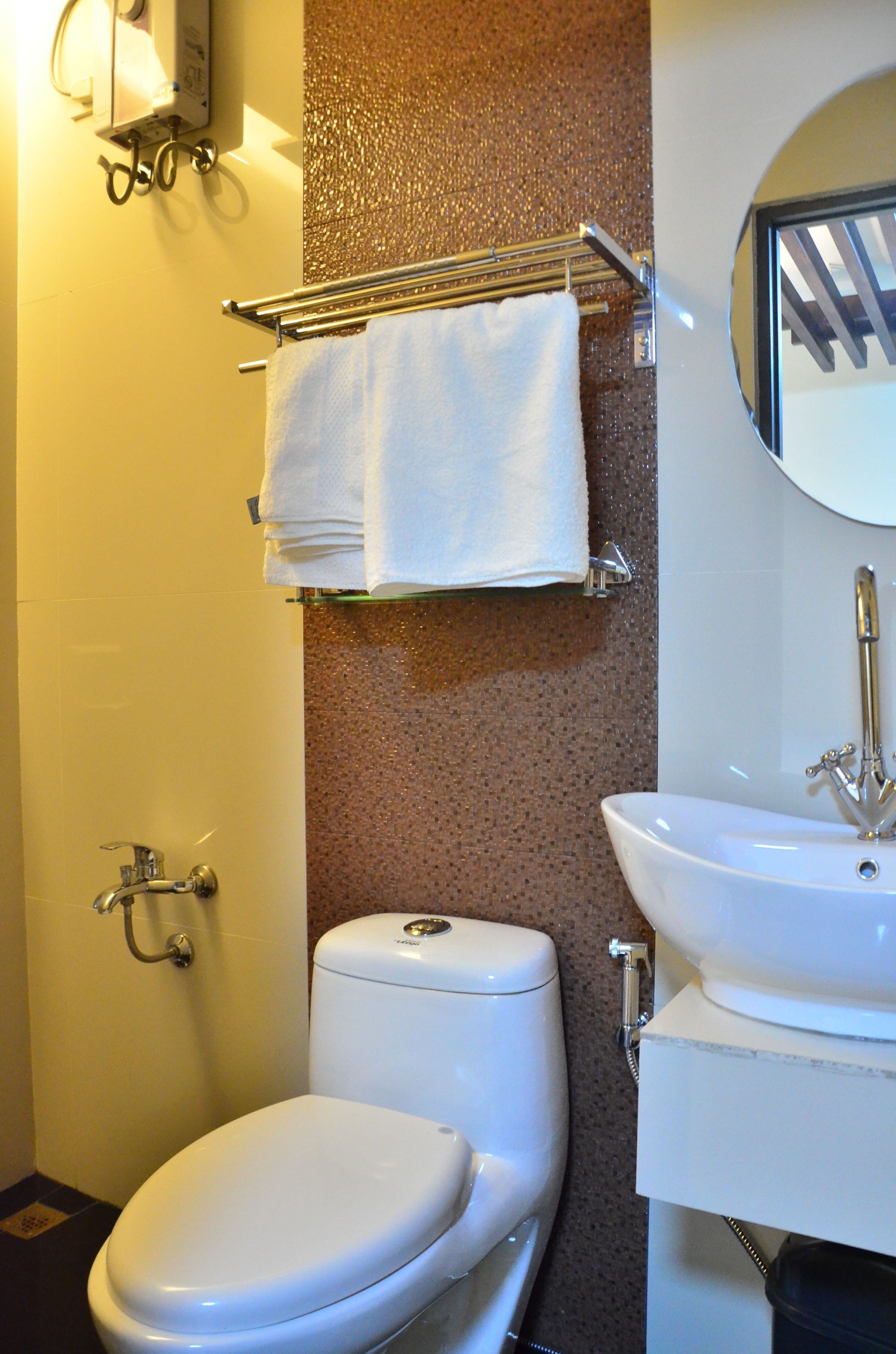 A bathroom with a toilet, sink, and towel rack.