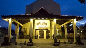 A traditional building with a covered entrance and statues in front. - SARE Suites (Jakarta)