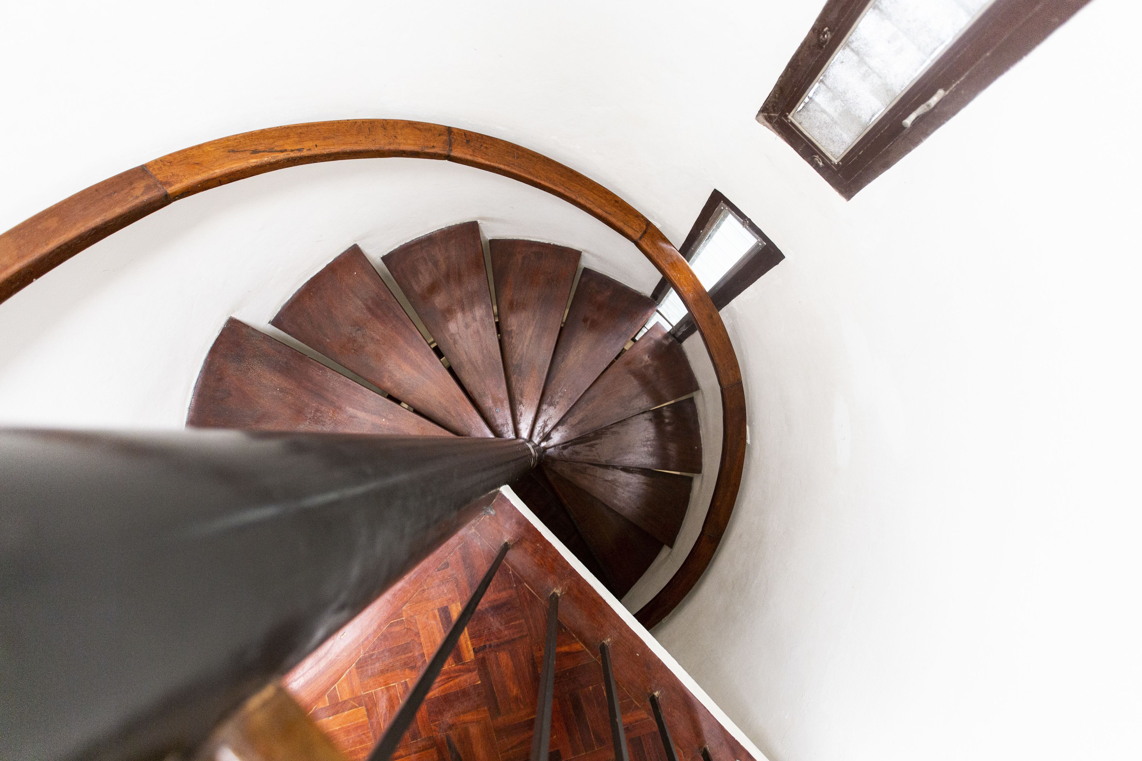 Un escalier en colimaçon avec des marches en bois et une rampe en bois.