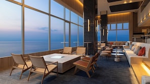 A modern interior with large windows, a seating area, and a view of the sea. - TAOYA Atami (Atami)