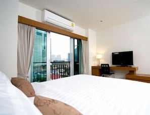 A hotel room with a bed, a TV, and a window with curtains. - Pannapat Place (Bangkok)