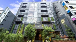 A modern hotel with a vertical garden facade, a prominent sign for the hotel, and a traditional architectural element at the entrance. - Pasela no Mori Yokohama Kannai (Yokohama)