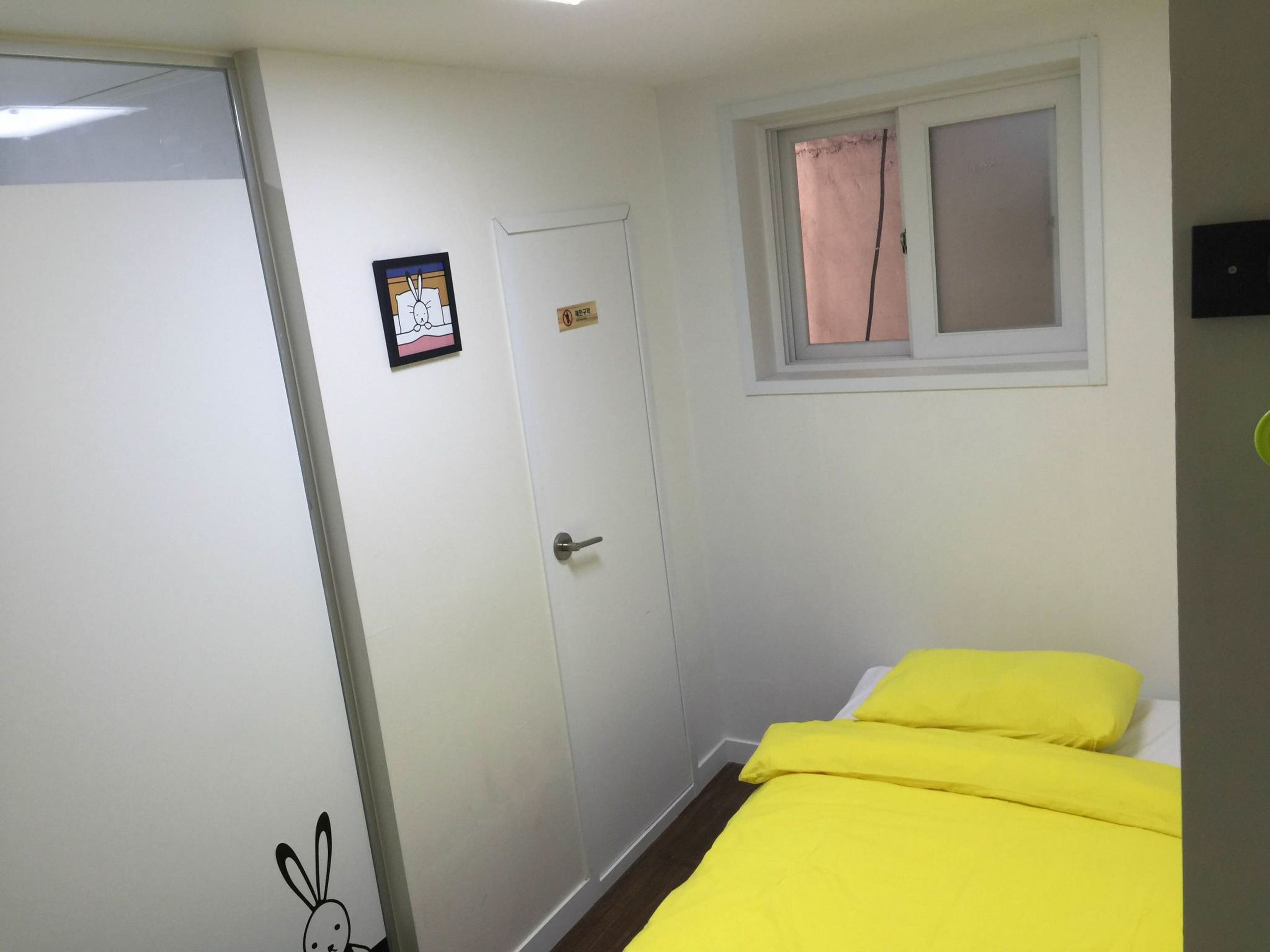 A room with a bed, a door, and a window.