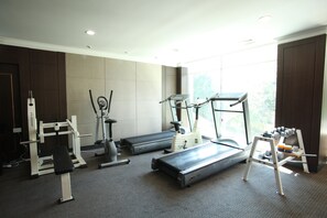 A gym with treadmills, a weight bench, and a rowing machine.