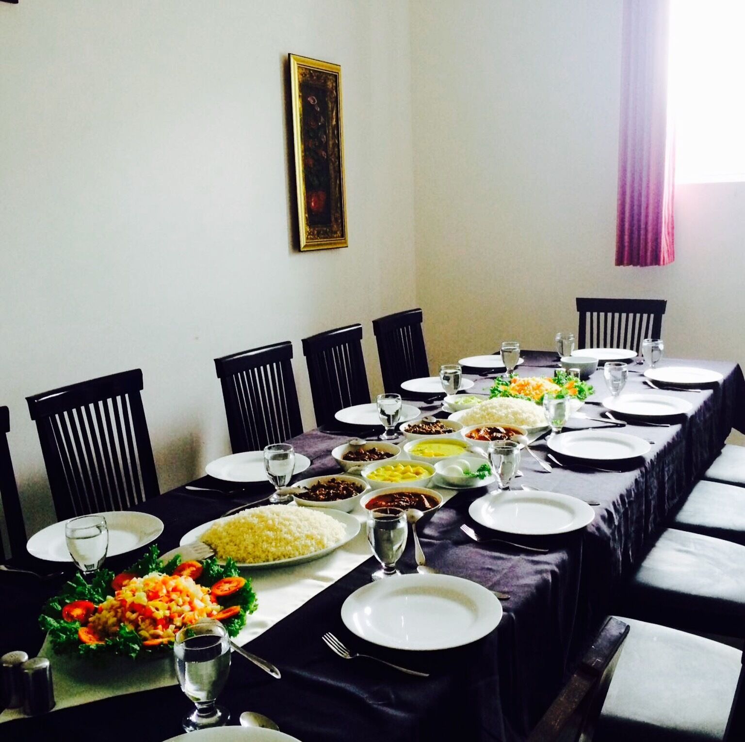 A dining table set for a meal with various dishes, glasses, and cutlery.