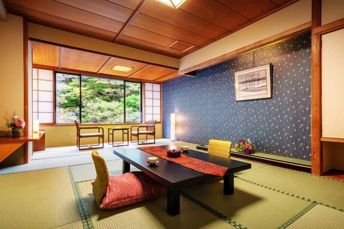 A traditional Japanese room with tatami flooring, a low table, and sliding doors.