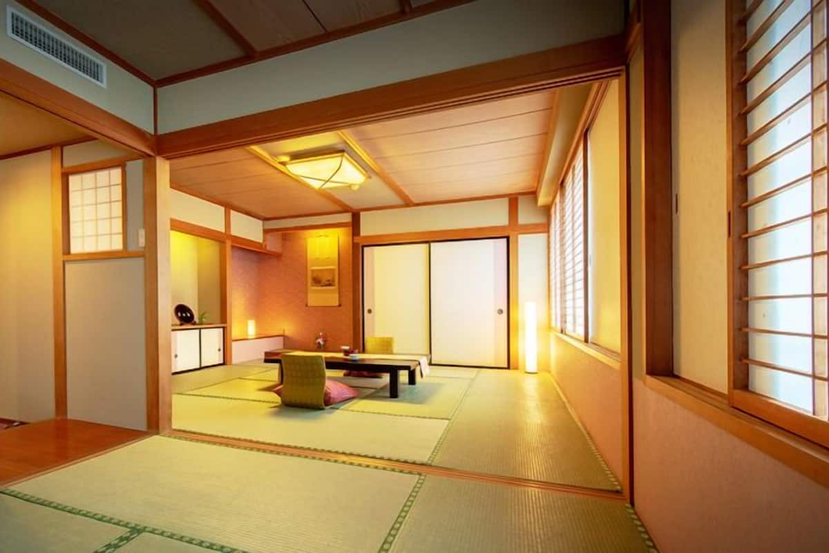 A traditional Japanese room with tatami flooring, sliding doors, and a low ceiling.