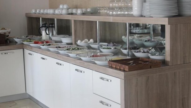 A buffet setup with multiple bowls of food, a coffee station, and a stack of plates. - Zeugma Park Hotel (Istanbul)