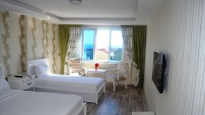 A hotel room with two beds, a small table, a chair, a TV, and a window with curtains. - Zeugma Park Hotel (Istanbul)