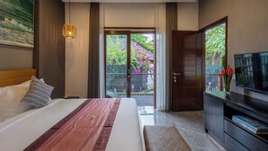 Habitación de hotel con cama, televisión, escritorio y vistas al exterior.