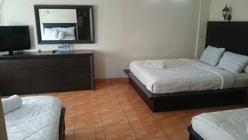 A hotel room with a bed, a dresser, a television, and a mirror.