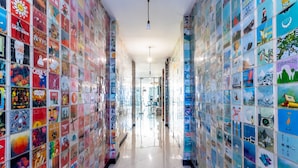 Corredor com paredes decoradas com cartazes e obras de arte coloridas.