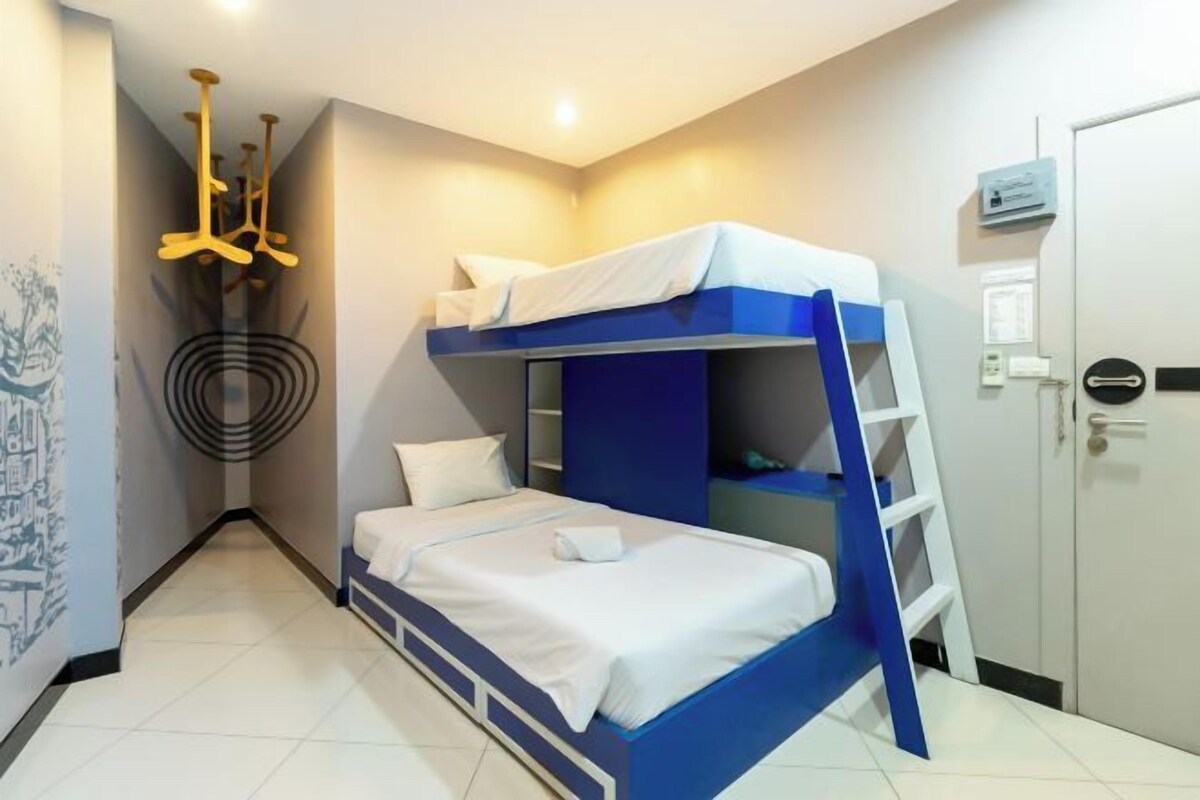A bunk bed room with a ladder, a white door, and a wall-mounted heater.