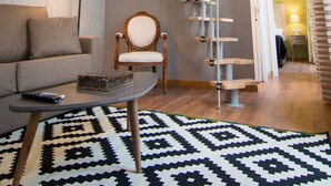 A modern living room with a staircase, a sofa, a coffee table, and a patterned rug. - Holidays2Malaga Comfort Apartments (Málaga)