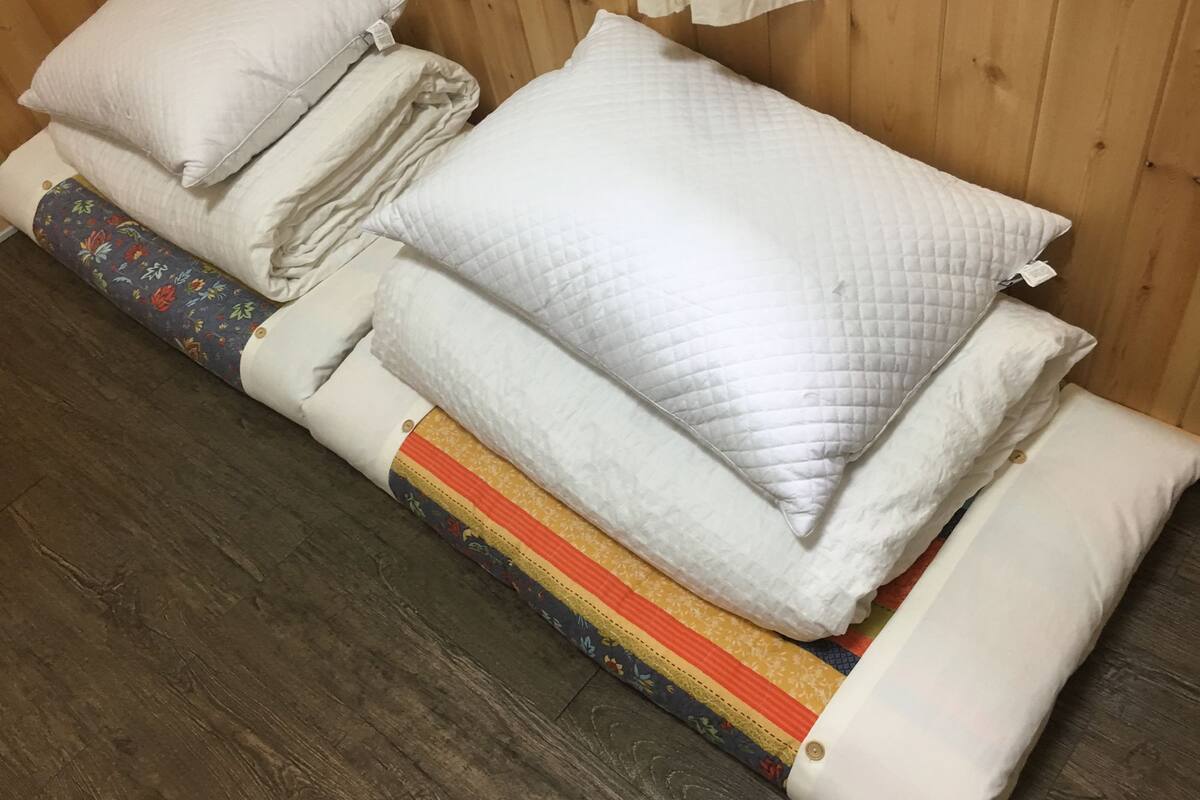 Een bed met meerdere kussens en een gewatteerde deken.