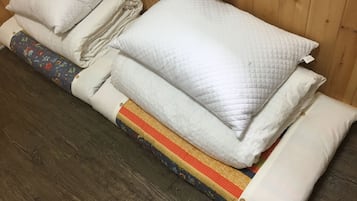 A bed with multiple pillows and a quilted blanket.