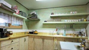 Een kleine keuken met houten kastjes, een aanrecht en een spoelbak.