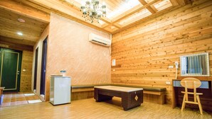 A wooden interior with a bench, a small table, and a chair. - Hai Yuan Hotel 2 (Hengchun)