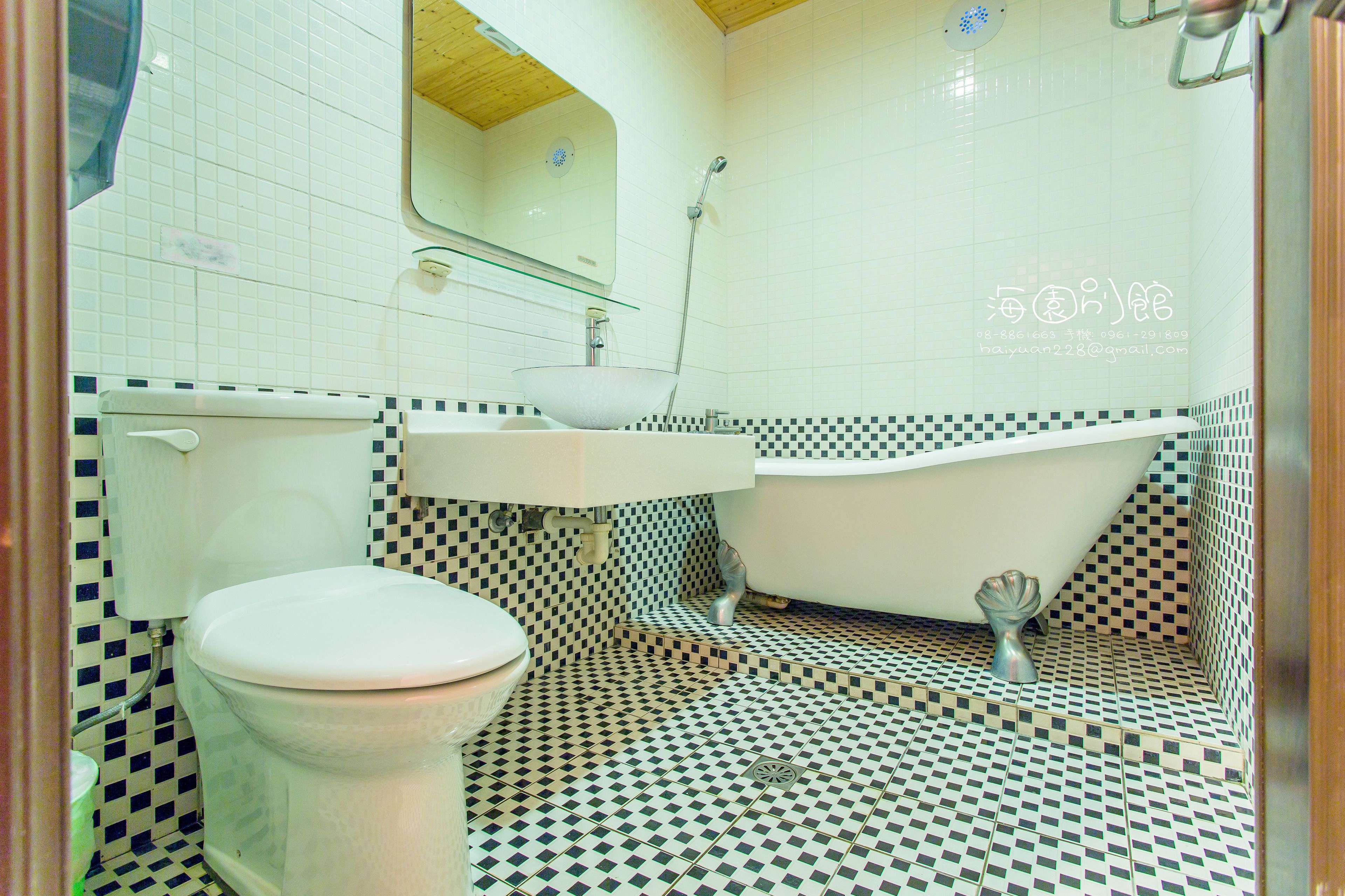 A bathroom with a toilet, sink, and bathtub.