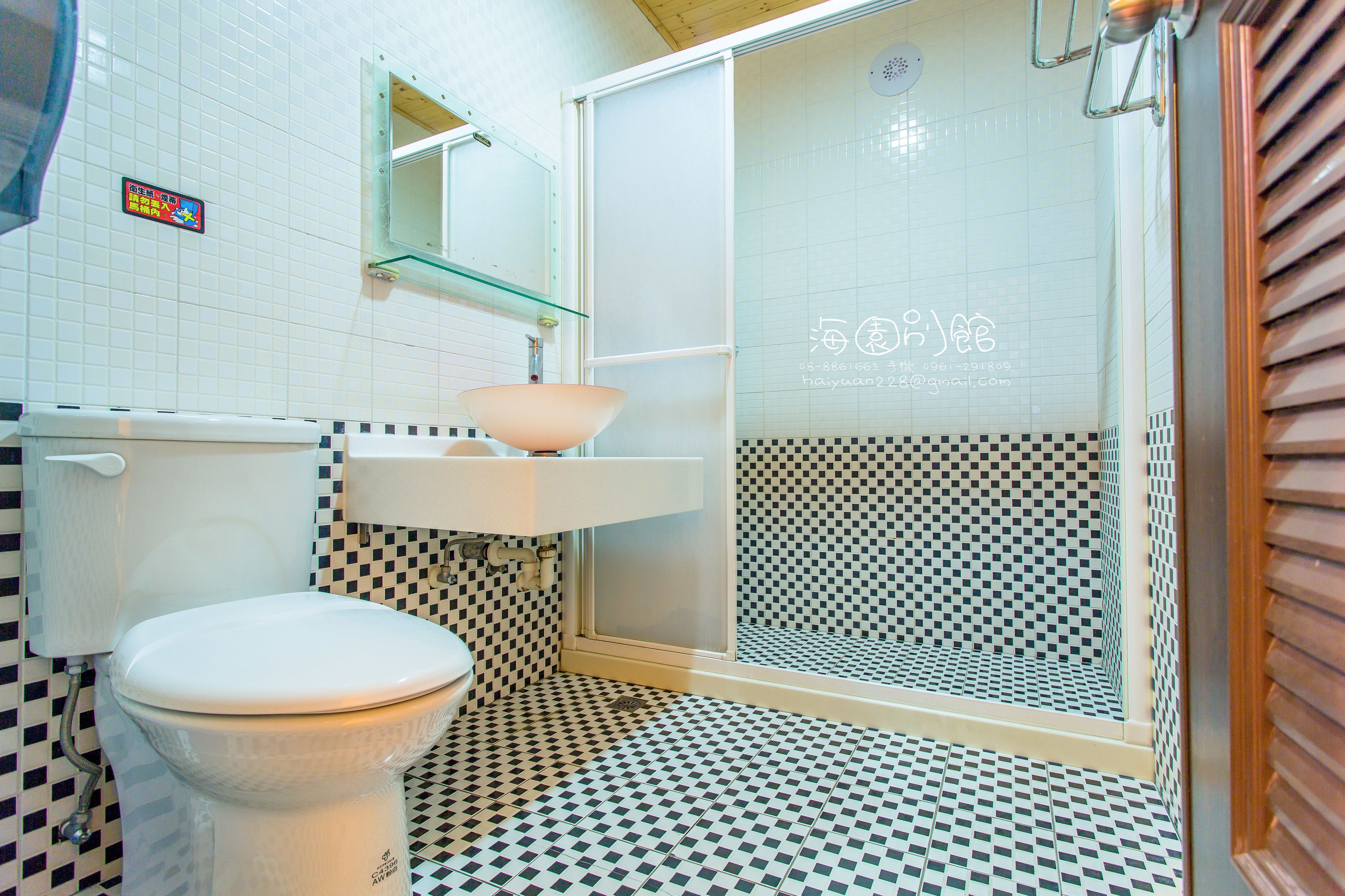 A bathroom with a toilet, sink, and shower.
