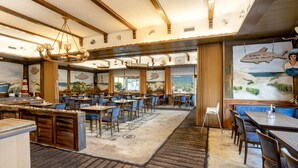 A restaurant with a nautical theme, featuring wooden furniture, a large mural of a coastal scene, and a bar area. - Familien- & Aparthotel Strandhof (Butjadingen)