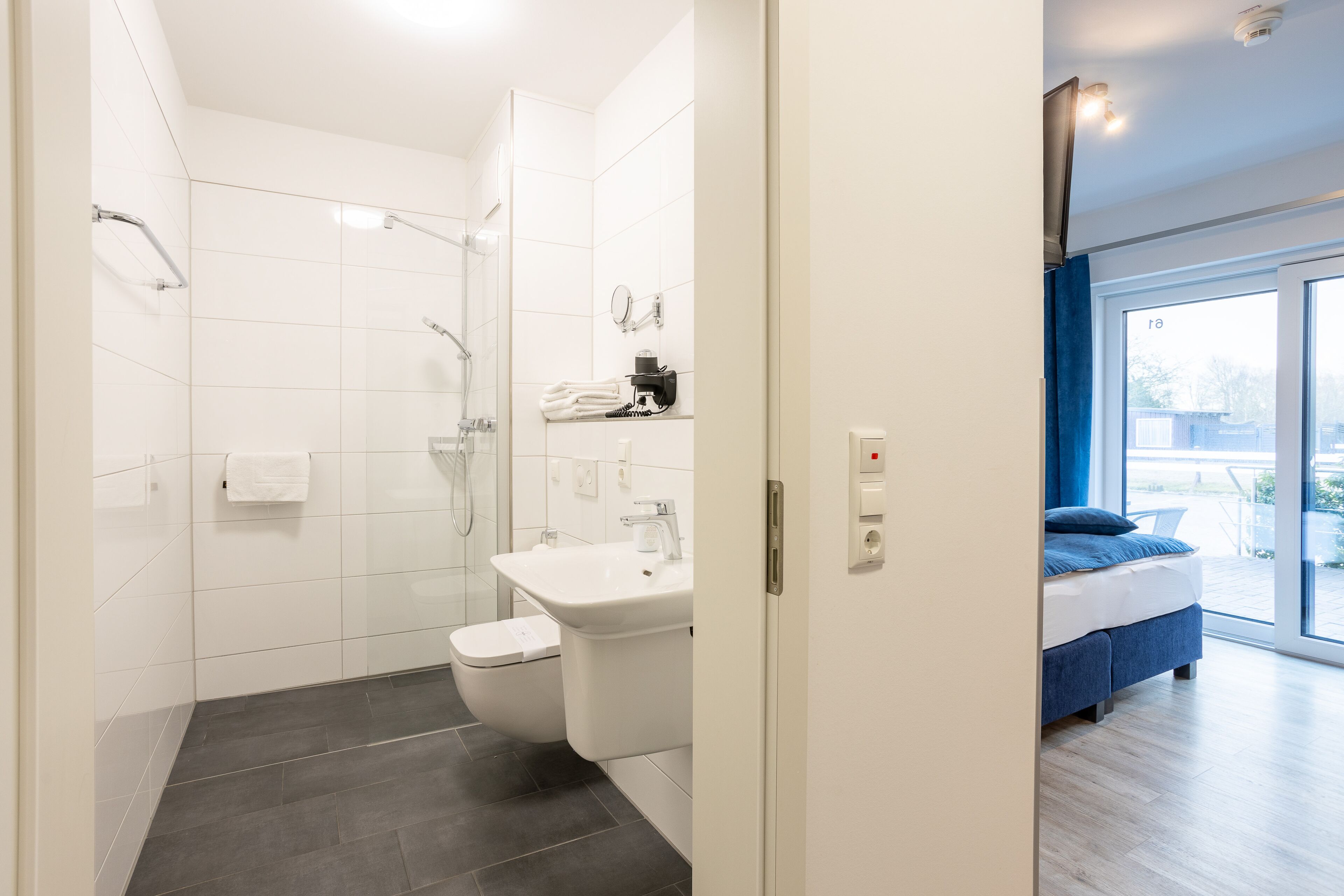 A modern bathroom with a shower, toilet, and sink.