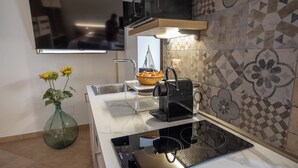 A modern kitchen with a built-in stove, a microwave, and a basket of bread on the counter. - B&B La Suite (Milazzo)