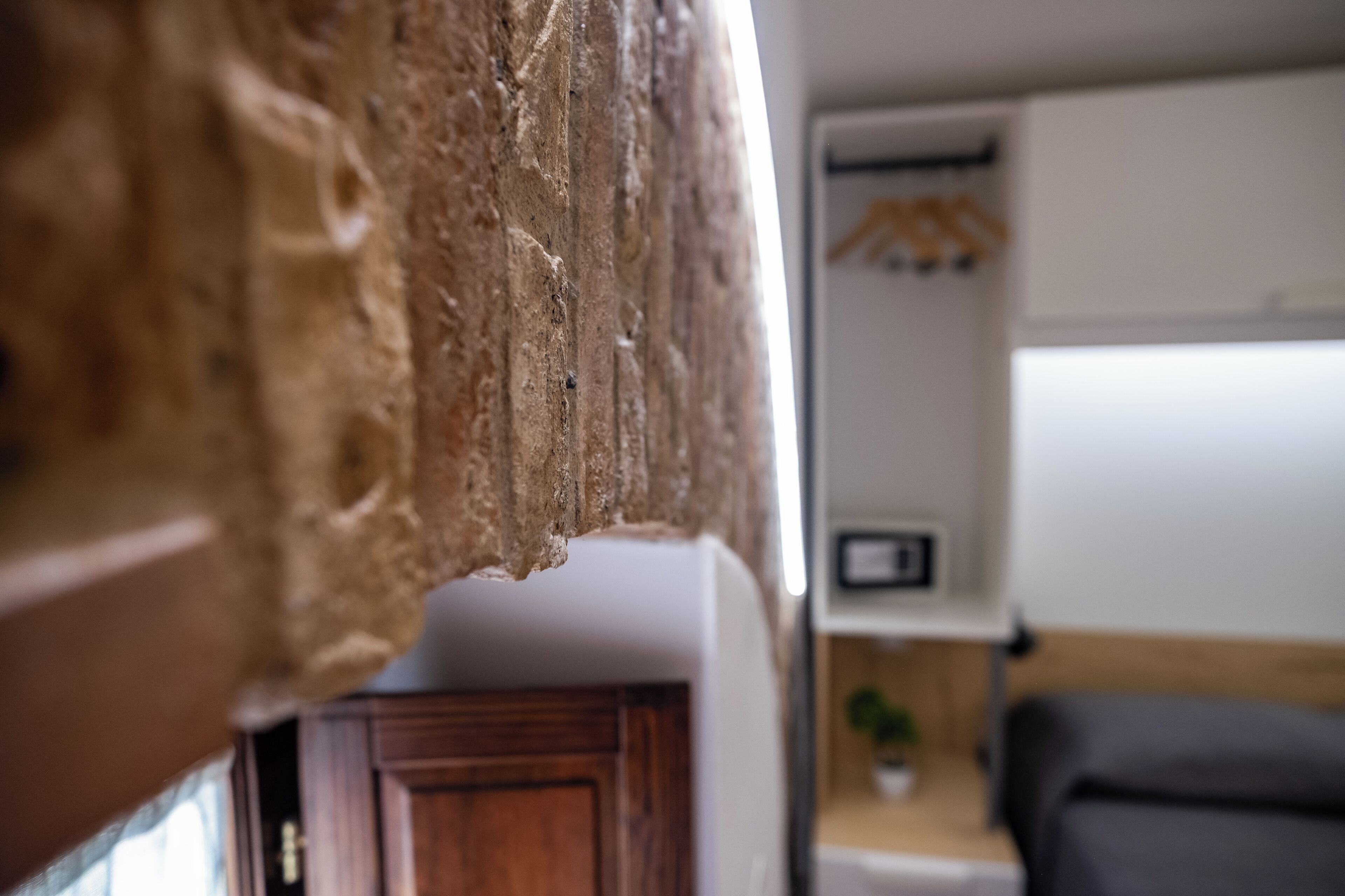 A close-up of a textured wall with a wooden door partially visible.