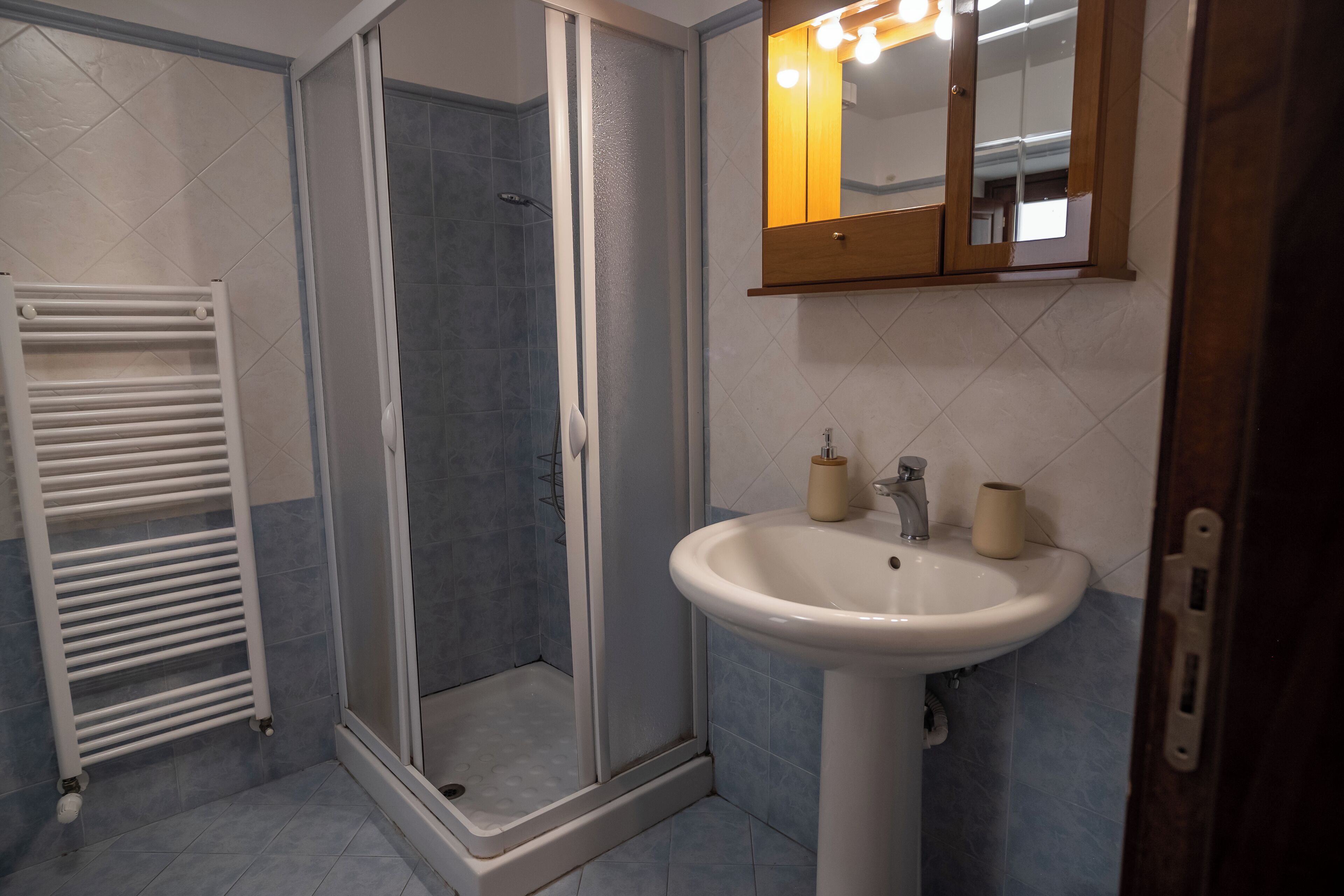 A bathroom with a shower, a sink, and a mirror.