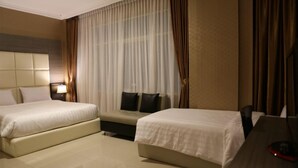 A hotel room with two beds, a desk, a lamp, and a large window with curtains. - Hotel 55 (Jakarta)