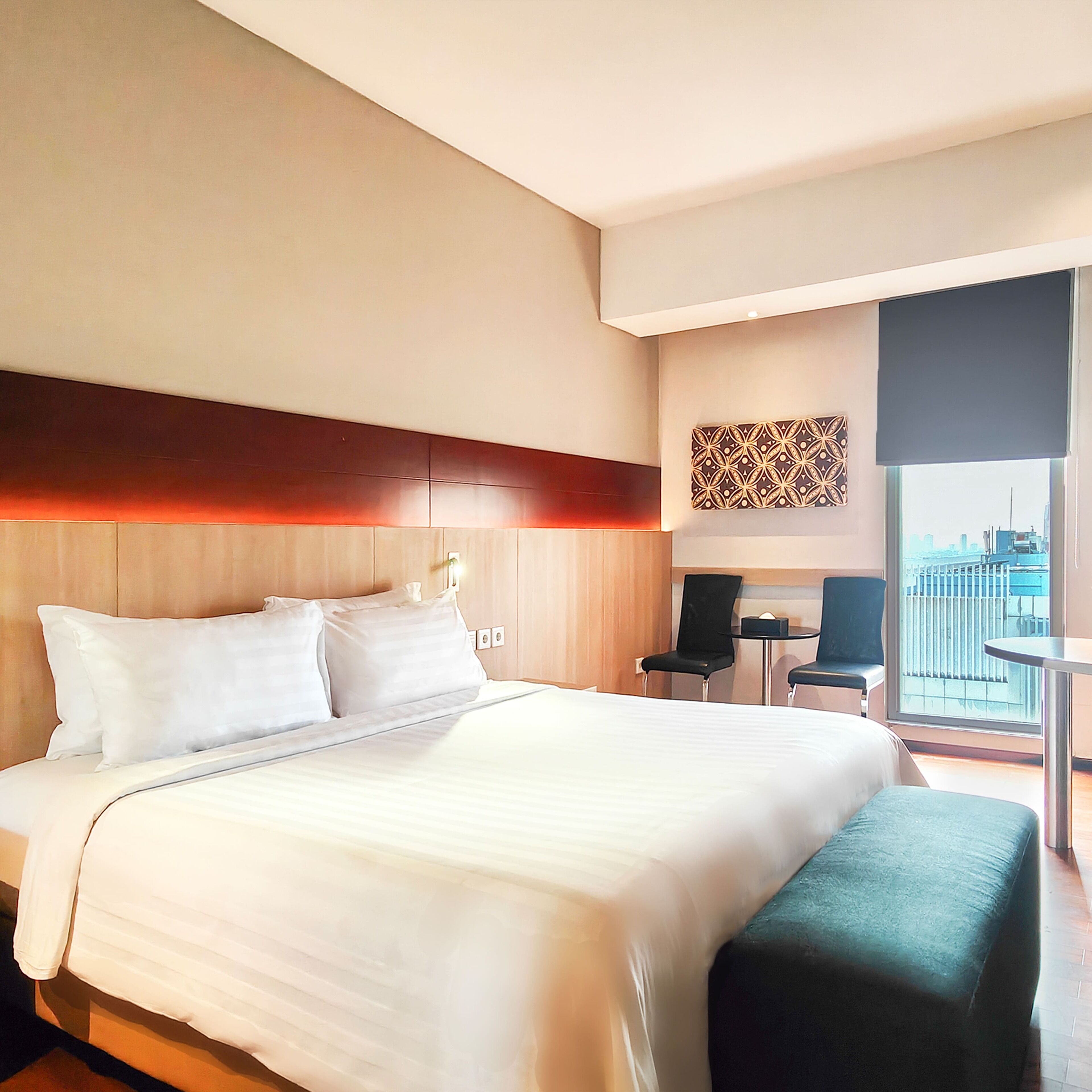 Una habitación de hotel con una cama grande, un escritorio y una silla.