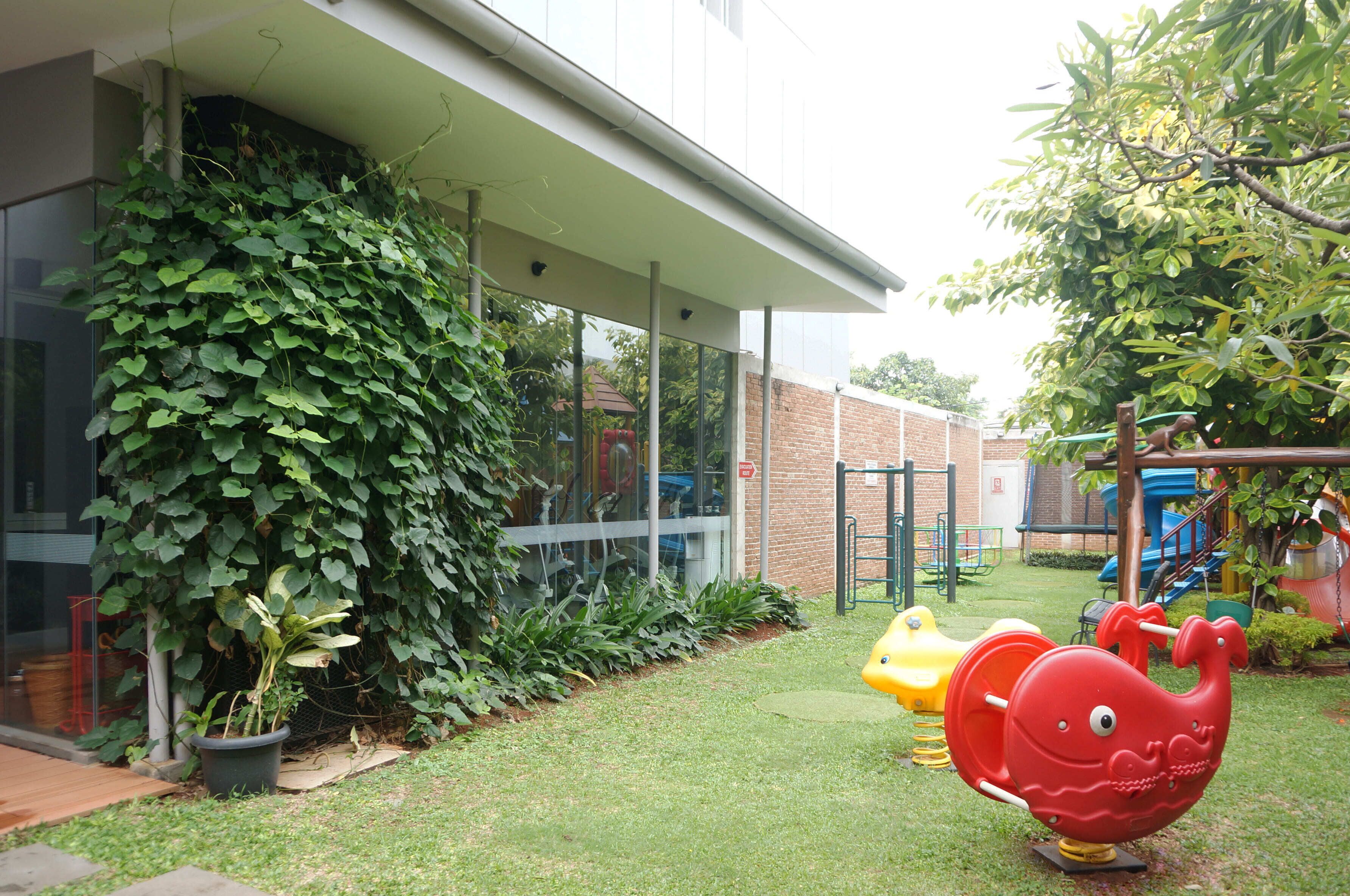 A children's play area with a slide, climbing structures, and a red whale-shaped swing.