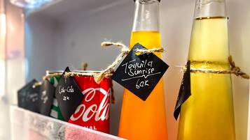A refrigerator shelf with bottles of beverages and a Coca-Cola can.
