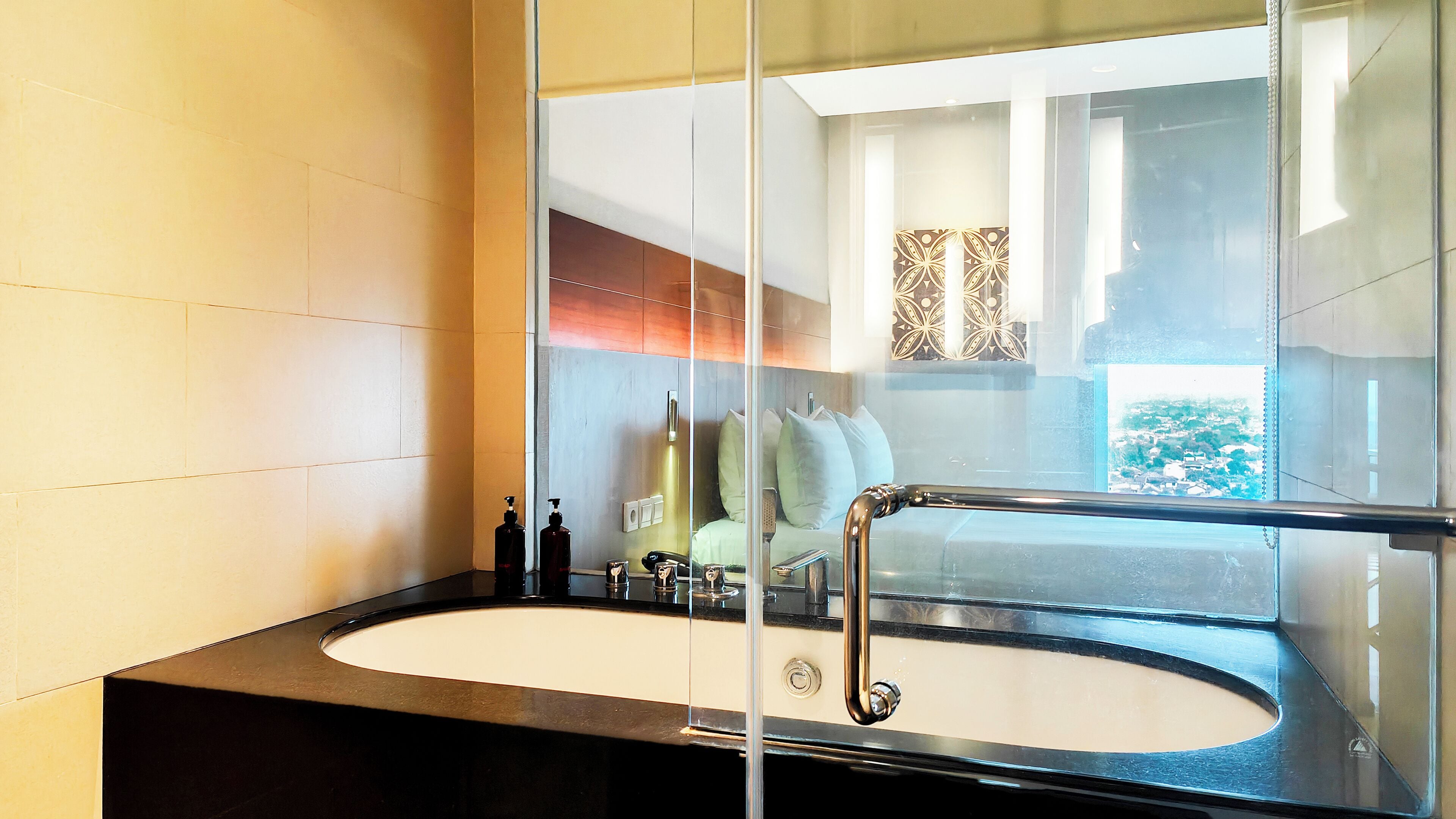 Un bagno moderno con uno specchio grande, una vasca e un water.