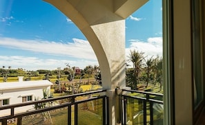 Varanda com vista para uma paisagem rural, incluindo campos e alguns edifícios.