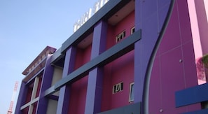 A multi-story building with a modern architectural design, featuring a combination of purple and pink colors. - Twin Star (Surakarta)