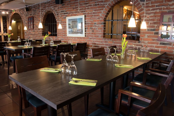 Un restaurant aux murs en briques, aux tables et aux chaises en bois.