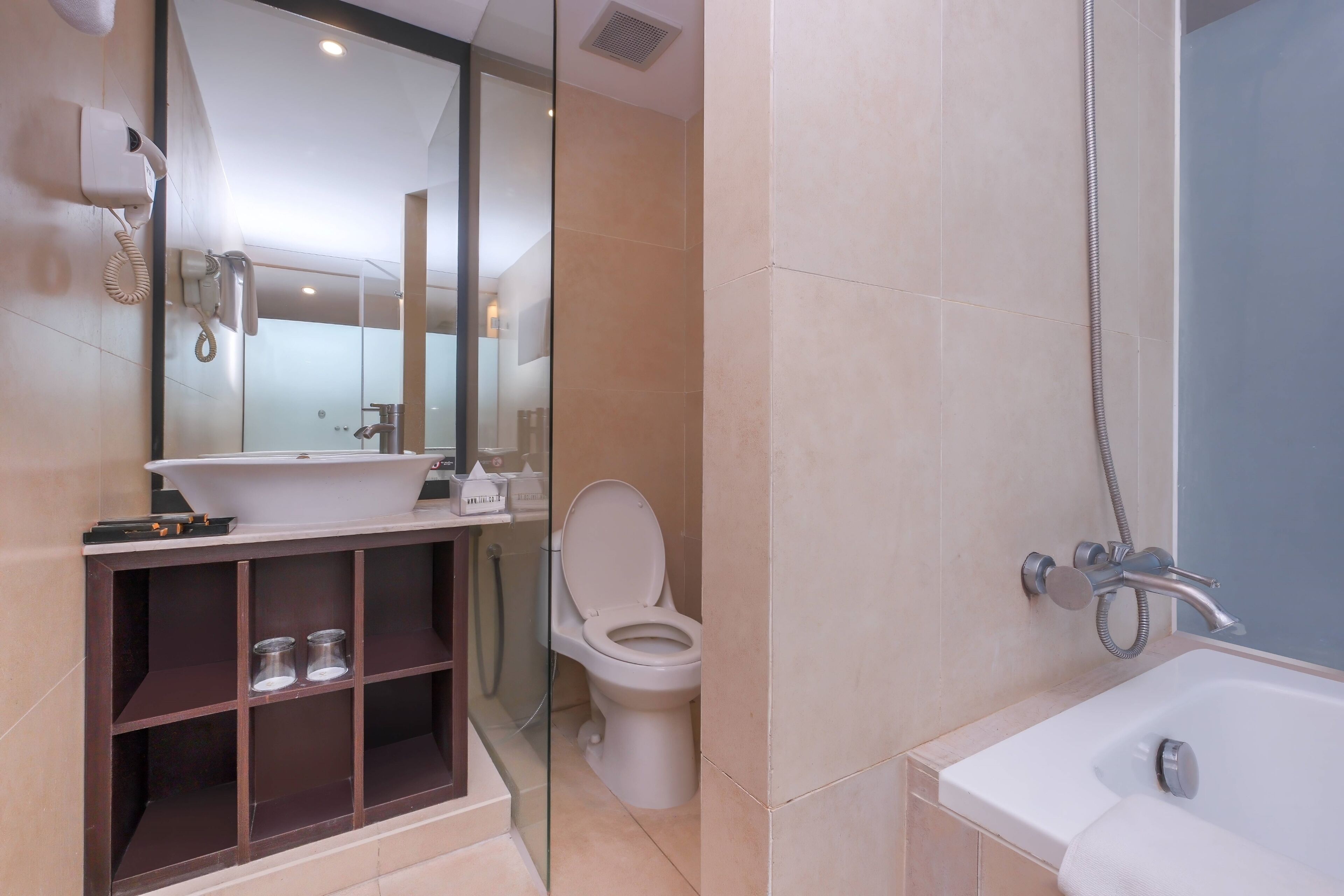 A modern bathroom with a bathtub, toilet, and vanity.