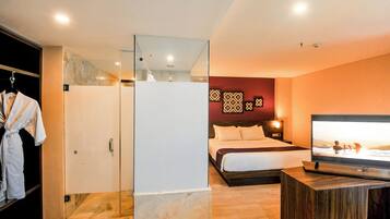 Une chambre d’hôtel équipée d’un lit, d’une télévision, d’une armoire et d’un miroir.