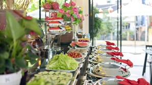 Un bufé con diversos alimentos y una planta decorativa al frente.