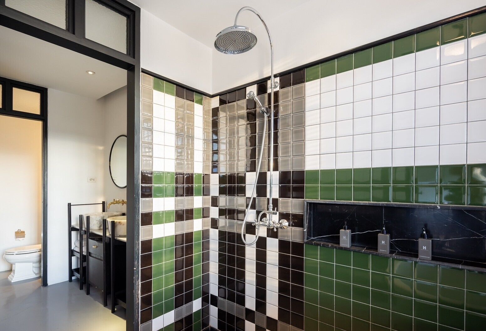 A modern bathroom with a shower, a toilet, and a sink.