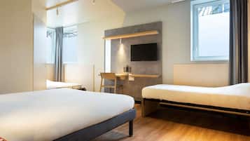 Una habitación de hotel moderna con dos camas, un escritorio, un televisor y un ventanal grande.