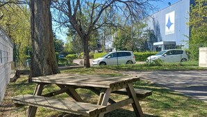 A picnic table in a grassy area with a building in the background. - ibis Budget Antony Massy (renovated 2024) (Antony)