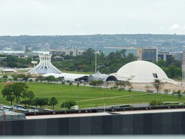Un estadio grande con una cúpula blanca distintiva y una estructura moderna y curvada al fondo.